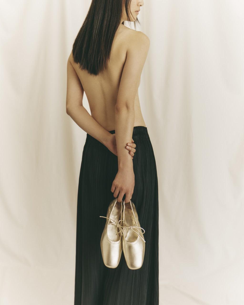 Minimalist shot of Lola Mary Jane Comet flats in hand