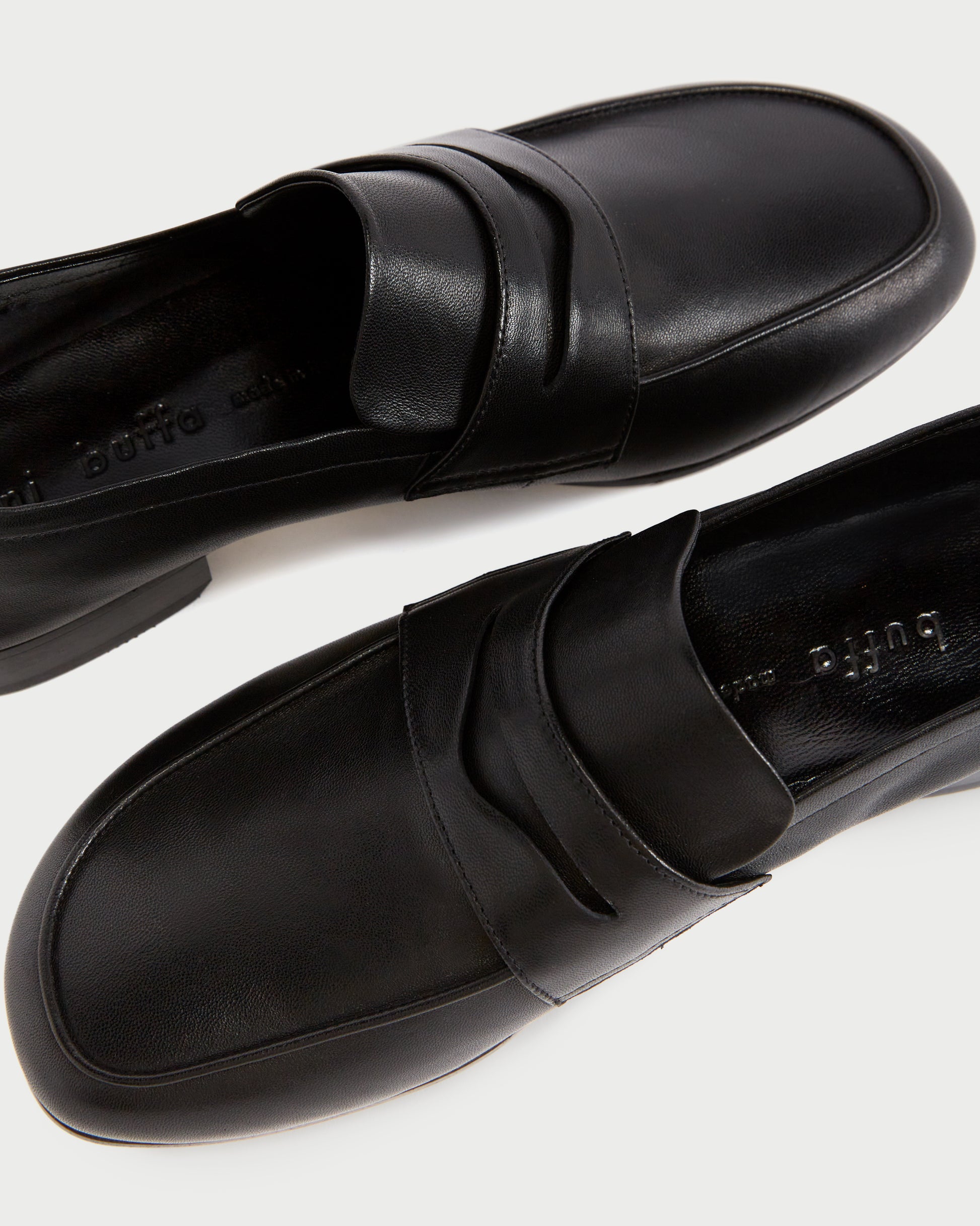 A close-up side view of  FEZ PENNY LOAFER in BLACK