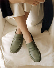 Load image into Gallery viewer, A model wearing Yuni Buffa Fez Penny Loafer shoes in Sage Green. Artisanal crafted women designer loafer shoe made in Italy with Italian Lamb Nappa leather.