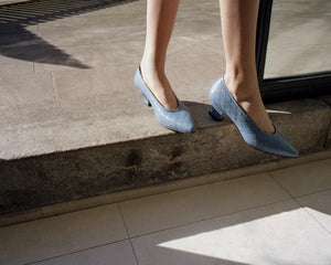 A model walking wearing Yuni Buffa Roma Pump shoes in Bermuda blue. Comfortable artisanal crafted designer high-heels made  in Italy with Italian Lamb Nappa leather