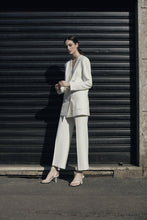 Load image into Gallery viewer, A model in white suit wearing Yuni Buffa Castrise Heel in Cloud white color made in Italy with Italian Lamb Nappa leather and silver logo buckle